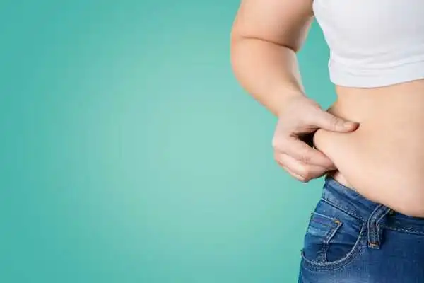 Image of woman pinching her love handles to show weight gain Twyford